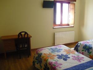 拉瓦纳尔德尔卡米诺La Candela的一间卧室配有一张床、一张书桌和一个窗户。