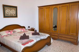 阿韦特拉纳Forte apartments "Enjoy Salento"的一间卧室配有一张床和一个木制橱柜