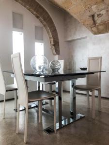 莱切Cuore Barocco的一间用餐室,配有黑色的桌子和椅子