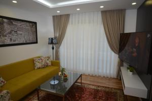 萨拉热窝Apart Hotel Family的客厅设有黄色沙发和电视
