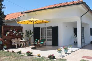 阿威罗Casa das Camélias的庭院配有遮阳伞和桌椅。