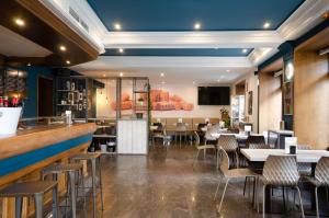 罗德里戈城Hotel Puerta Ciudad Rodrigo的一间带桌椅的餐厅和一间酒吧