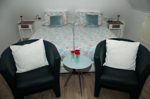 兹沃勒德兰根里住宿加早餐旅馆的一间卧室配有一张带两把椅子和一张桌子的床。