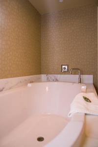 贝滕多夫Isle Casino Hotel Bettendorf的浴室内设有带水龙头的白色浴缸