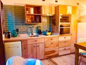 纳塔列斯港DT Loft的厨房配有木制橱柜和蓝色瓷砖墙。