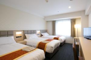 东京东京良日酒店的一间酒店客房,设有三张床和一台平面电视