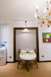 河内Hong Gia Tue Apartment的一间带桌椅和吊灯的用餐室