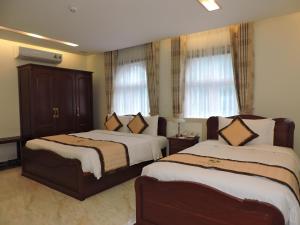 胡志明市Minh Tam Phu Nhuan Hotel & Spa的酒店客房带两张床和两个窗户