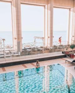 尼斯凯悦尼斯地中海宫殿酒店的游轮上游泳池中的女人