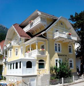 富尔普梅斯Hotel Garni Hubertus-Nostalgie & Charme的黄色房子,在街上设有白色阳台