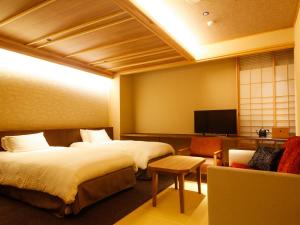 南淡路市Minato Koyado Awajishima的一间酒店客房,设有两张床和电视