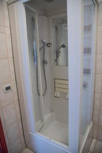 贾迪尼-纳克索斯艾斯诺斯宫殿酒店的浴室里设有玻璃门淋浴