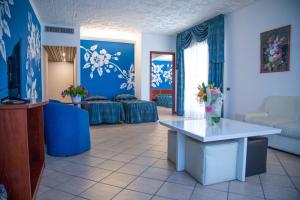 贾迪尼-纳克索斯艾斯诺斯宫殿酒店的客厅拥有蓝色的墙壁和鲜花桌