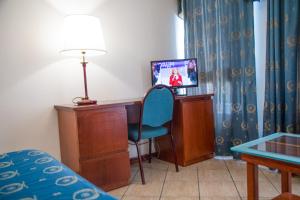贾迪尼-纳克索斯艾斯诺斯宫殿酒店的客房设有书桌、床和电视。