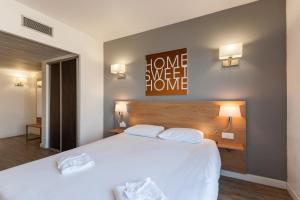 马赛渣油格兰德布拉多酒店的卧室配有一张带两个枕头的大白色床