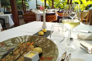 格兰贝伊Ocean Villas Hotel的桌上的一小块食物,加上一杯葡萄酒