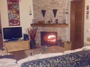 Albalate de ZoritaCasa Rural Lago Bolarque的客厅设有壁炉和沙发。