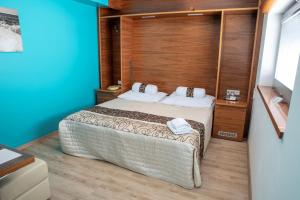 布尔诺内姆阿尔什时尚餐饮酒店的一间卧室配有一张木墙床