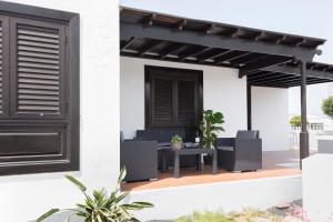 宏达海滩Apartamento playa coqueto junto al mar的一个带黑色凉棚和椅子的庭院