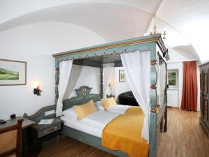 德意志兰茨贝格伯格德意志兰茨贝格酒店的一间卧室配有一张带黄床单的天蓬床