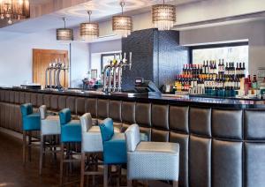 泰恩河畔纽卡斯尔Leonardo Hotel Newcastle Quayside的一间酒吧,餐厅里摆放着蓝色的椅子