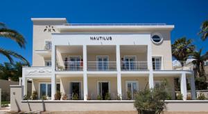 卡利亚里诺迪鲁斯酒店的棕榈树海滩上的白色建筑