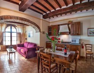 阿夸维瓦桑格因内托农舍酒店的客厅配有桌子和紫色沙发
