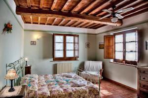 阿夸维瓦桑格因内托农舍酒店的一间卧室配有一张床和吊扇