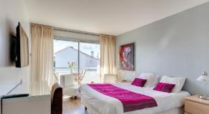 弗雷瑞斯Hotel Sable Et Soleil - Port, Plage et spa的一间卧室设有一张大床和一个大窗户