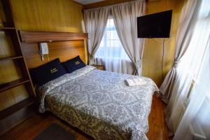 蓬塔阿雷纳斯帕雷迪索旅馆的一间卧室配有一张床、一台电视和一个窗口