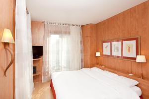 巴黎贝斯特韦斯特隆赛雷剧院酒店的卧室配有白色的床和窗户。