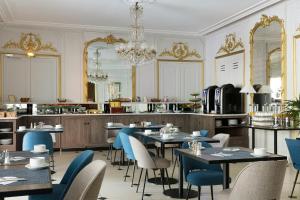 巴黎贝斯特韦斯特隆赛雷剧院酒店的一间带桌椅和吊灯的餐厅