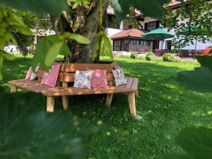 若特阿赫-埃根阿皮纳巴赫迈尔酒店的木凳坐在树下的草下