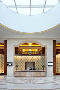 迪拜Crowne Plaza - Dubai Jumeirah, an IHG Hotel的两人坐在大楼的大厅里