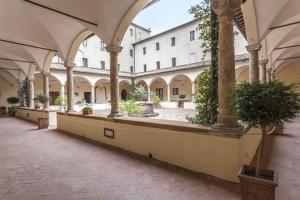 皮恩扎瑞雷斯切奥斯托迪皮耶扎酒店的庭院里一座大建筑,有柱子和植物