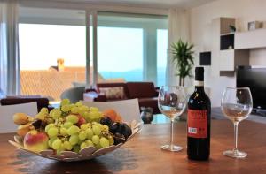 伊齐齐Apartments Anna的一瓶葡萄酒和一碗水果放在桌子上
