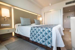 美洲海滩尔卡诺春天酒店的一间卧室配有一张带蓝色枕头的大床