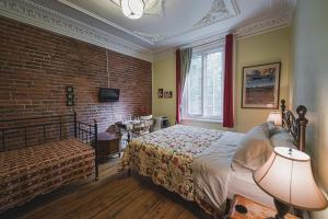 蒙特利尔镇中心阿德雷斯酒店的一间卧室设有一张床和砖墙