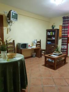 潘潘埃拉Hostal Pampaneira的客厅配有桌子和电视