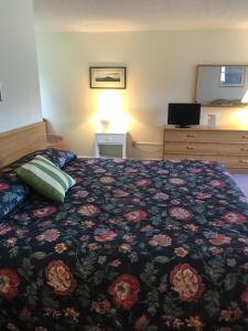 Twin MountainFour Seasons Motor Inn的一间卧室配有一张带花卉床罩的床