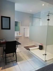 开普敦The Palm的浴室设有玻璃淋浴间、桌子和水槽