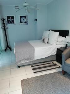 开普敦The Palm in Pinelands的一间卧室设有一张床和蓝色的墙壁