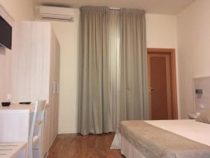 蓬泰代拉拉佩斯酒店的一间卧室配有一张床、一张书桌和一个窗户。