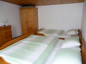 于克里茨Haus Frohsinn的一间卧室设有两张床和木制橱柜