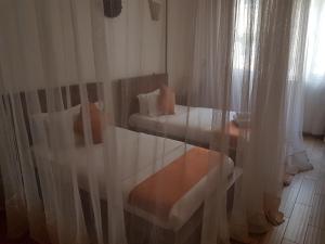 基苏木The Vic Hotel的一间卧室设有两张床,窗户配有窗帘