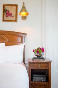 洛杉矶卡尔弗酒店的一张带桌子的床,上面放着一碗鲜花