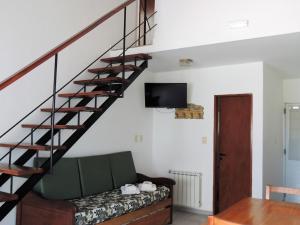 费德拉西翁IRUPÉ APART HOTEL的一间带楼梯和沙发的客厅