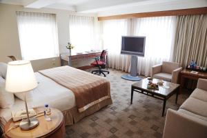 纽约The Prince Kitano New York的配有一张床和一张书桌的酒店客房