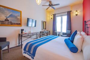 圣米格尔-德阿连德Hotel La Casona 30的一间卧室配有一张带蓝色枕头的大床