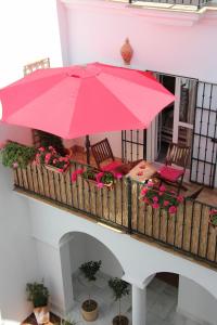 罗塔Casa Atlantica的鲜花阳台的大粉红色雨伞
